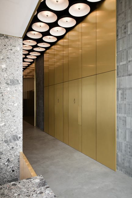 Press kit | 3809-01 - Press release | Warehouse GYM D3 - VSHD Design - Commercial Interior Design - The main corridor cladded in gold copper alloy leading to the male and female changing rooms with concealed doors of the same material. - Photo credit: Nik and Tam