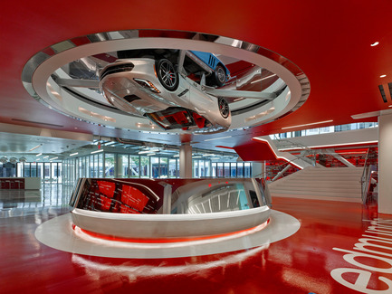 Press kit | 2222-01 - Press release | EdQuarters - M+M Creative Studio - Commercial Interior Design - Polished mirror chrome reception desk at main arrivals lobby with main stair adjacent and 2016 Corvette Sting Ray turning above  - Photo credit: Benny Chan @Fotoworks 