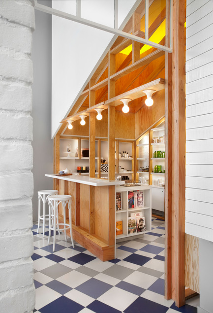 Press kit | 1048-08 - Press release | Reinventing the beauty salon experience with Her Majesty’s Pleasure - +tongtong - Commercial Interior Design - Serving double duty as a pop-up retail boutique and reception to the salon, the monolith is “a product display system grown out of an architectural construction,” says Tong. “It’s a structure within a structure.” The pitched roof language is another nod to tradition, resembling barns and tree houses alike, but the geometric wooden shelving, backlit by LEDs, is fully modern. - Photo credit: Lisa Petrole