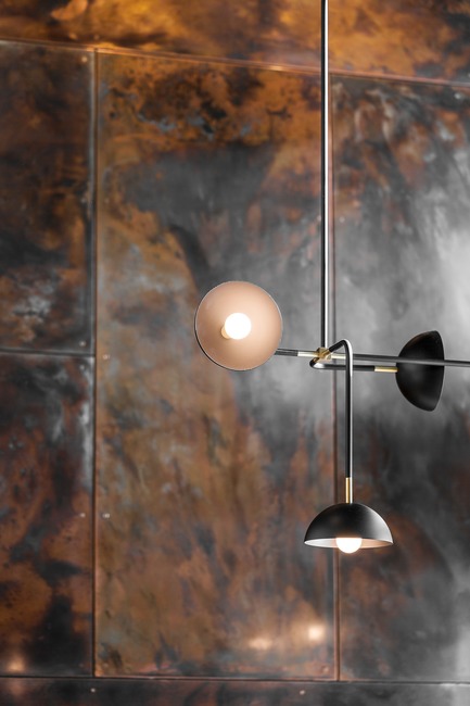 Press kit | 2886-02 - Press release | Wild Ginger Denny Triangle - SkB Architects - Commercial Interior Design - Beaubien Double Shade light by Lambert & Fils Studio with patinated copper paneling in the backdrop - Photo credit: Hannah Rankin