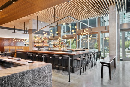 Press kit | 2886-02 - Press release | Wild Ginger Denny Triangle - SkB Architects - Commercial Interior Design - Central bar area and dining with custom light fixture feature Boci globes above - Photo credit: Ben Benschneider
