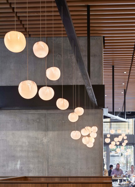 Press kit | 2886-02 - Press release | Wild Ginger Denny Triangle - SkB Architects - Commercial Interior Design - Warm lights from Bocci and wood slat ceiling element are set against raw concrete and blackened steel - Photo credit: Hannah Rankin