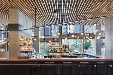 Press kit | 2886-02 - Press release | Wild Ginger Denny Triangle - SkB Architects - Commercial Interior Design - View through the bar featuring the cantilevered custom light fixture also designed by the architects - Photo credit: Ben Benschneider