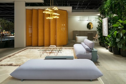 Press kit | 2704-05 - Press release | “Das Haus” 2019 at the imm cologne: Living by moods creates an appetite for open-plan homes - imm cologne 2019, Koelnmesse GmbH - Residential Interior Design - The new Press sofa (also seen here as a long pouf in the foreground) is a prototype (produced by Käfer & Hummel). It was developed by Studio Truly Truly for their Das Haus at imm cologne 2019 and was shown at the Cologne fair for the first time. The Serene zone with the bathroom and a sleeping area hidden behind panels is visible in the background. - Photo credit: Constantin Meyer; Koelnmesse