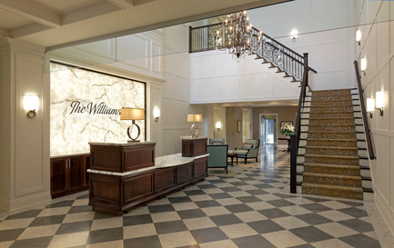 Press kit | 1855-01 - Press release | Newcombe Design Group’s approach to retirement living honoured with ARIDO Award - Newcombe Design Associates - Commercial Interior Design - The soaring lobby, concierge desk, lighting, feature stair and subdued color palette instantly convey the hotel-like character of this retirement residence. While meeting the clients’ request for a checkerboard tile floor pattern, we used a medium grey and cream stone tile in a matte finish to soften the contrast and glare - Photo credit: David Whittaker