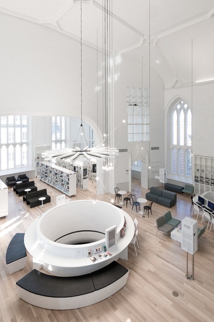 Press kit | 721-07 - Press release | Maison de la littérature(House of Literature) - Chevalier Morales Architectes - Institutional Architecture - The large circular opening in the library’s floor and the hanging contemporary light fixture  - Photo credit: Chevalier Morales Architectes