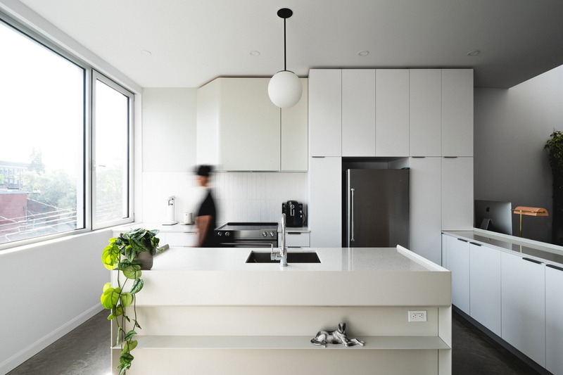 Press kit | 1142-07 - Press release | Off Plaza: L. McComber meets la Maison du Rotin - L. McComber – architecture vivante - Residential Architecture - The compact but sunny kitchen, open to the city and living areas. - Photo credit: Raphaël Thibodeau